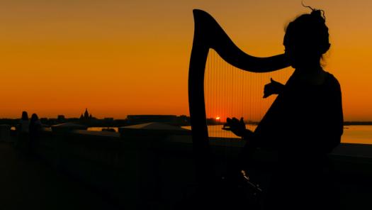 Playing the harp at sunset